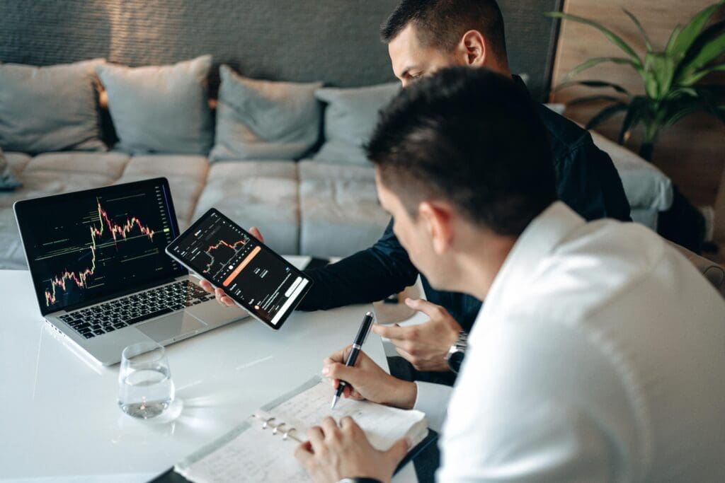Professionals analyzing financial charts on laptop and tablet, highlighting fintech innovation Europe and rising cybersecurity demand Title Fintech Innovation Europe and Cybersecurity Demand Analysis Caption Experts reviewing financial data and market trends, reflecting the growth of fintech innovation Europe, cybersecurity demand, and the need for nearshore cybersecurity teams Description This image shows two professionals an